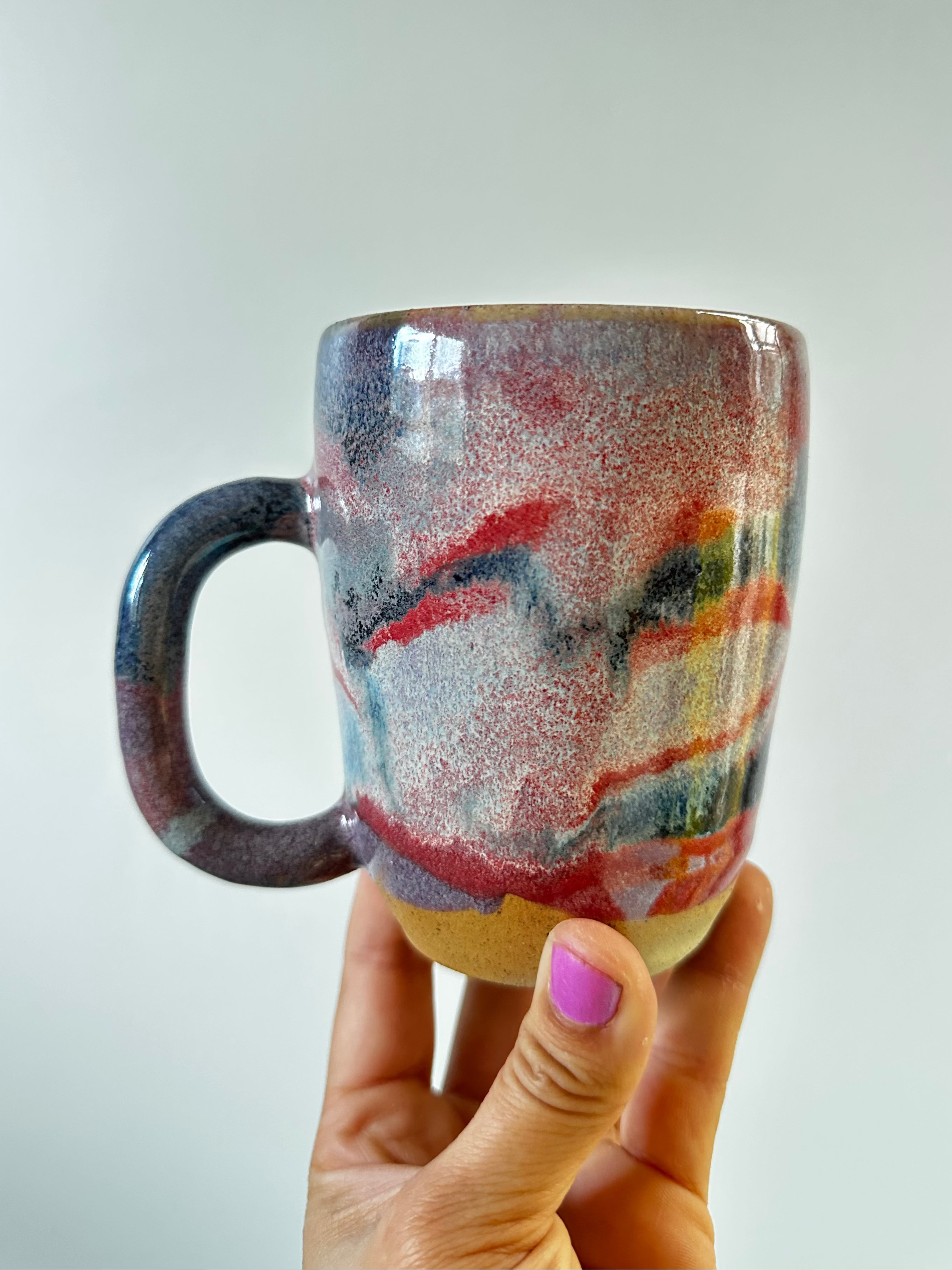 A hand holds up a large mug