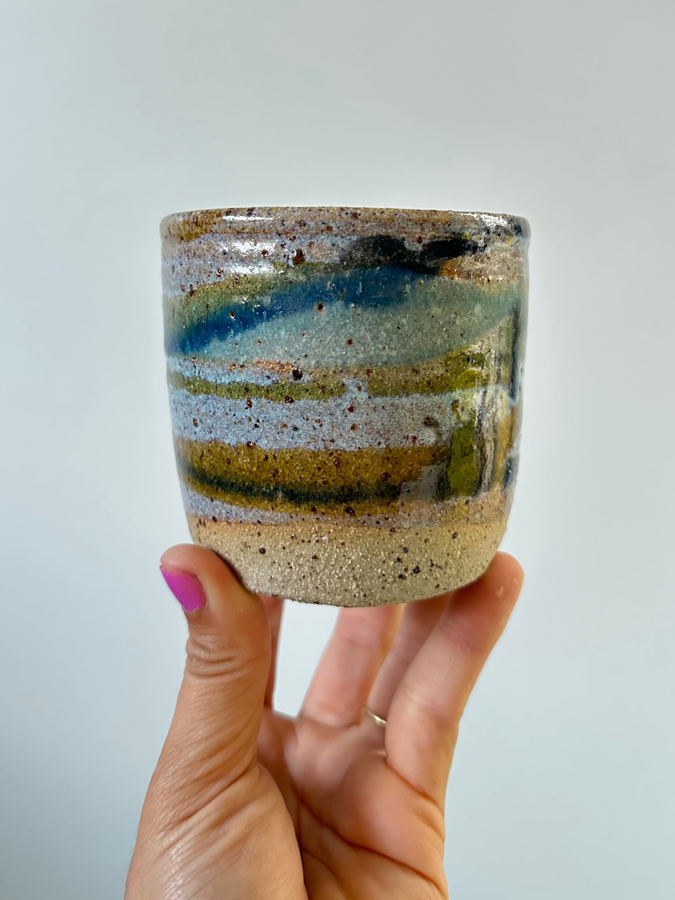 a hand holding a planter with a landscape pattern