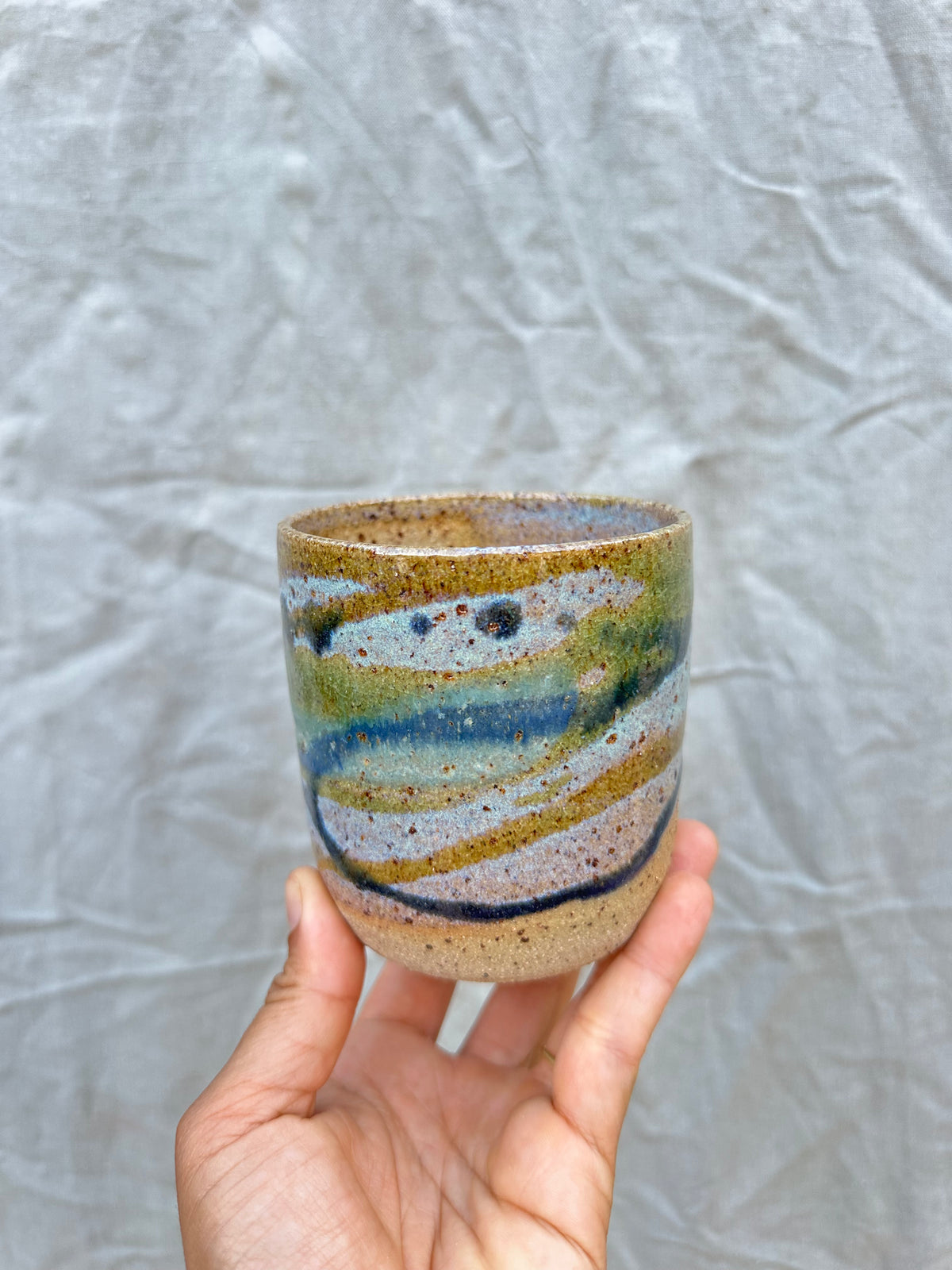 handmade ceramic planter held against a grey background