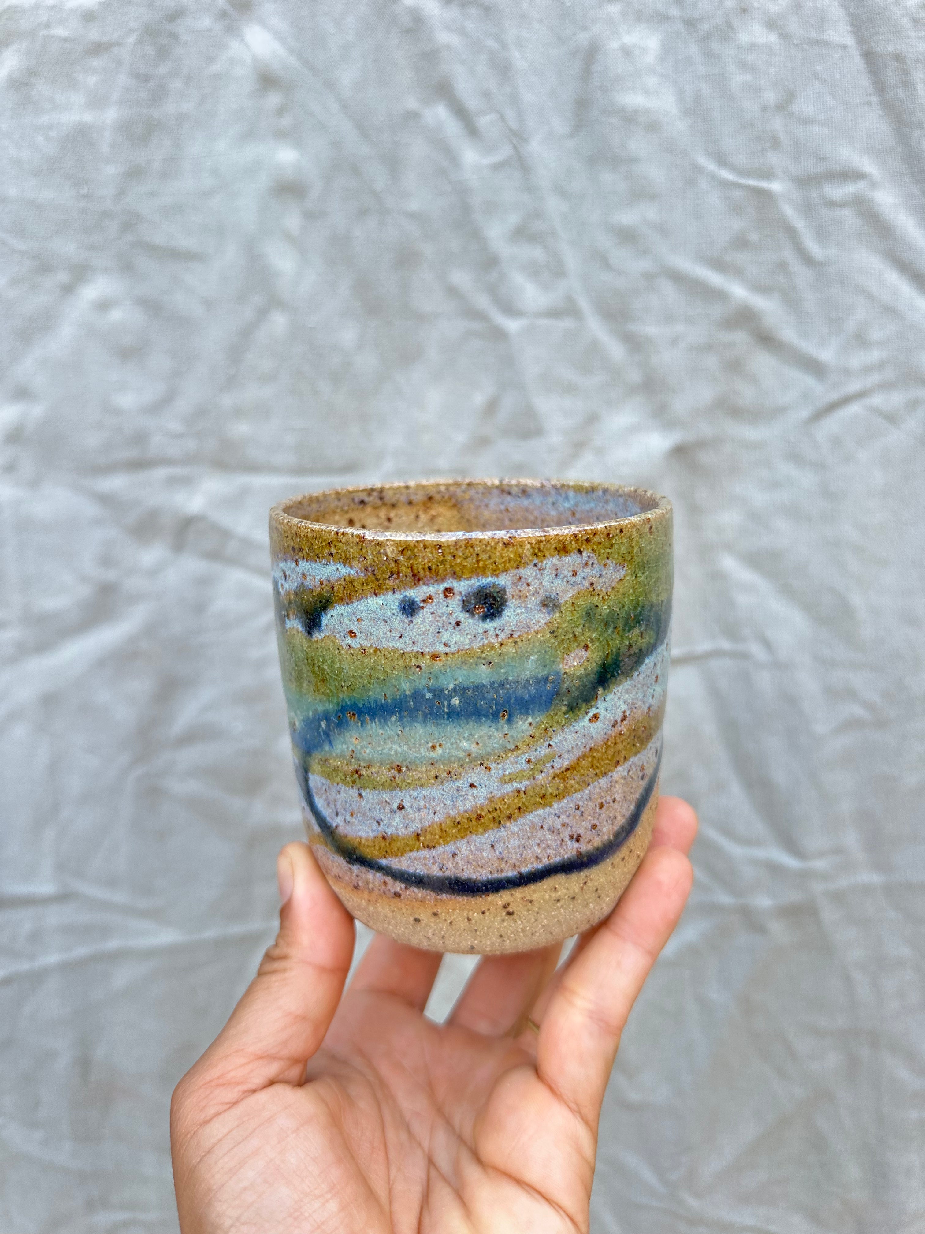 handmade ceramic planter held against a grey background